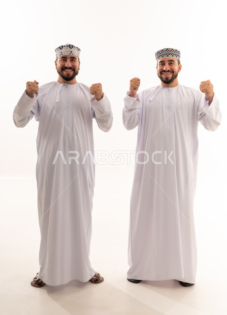 Two Omani Men Celebrating Success in Traditional Dress