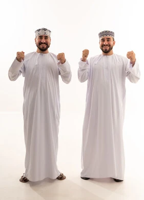 رجلان عمانيان يحتفلان بالنجاح بالزي العماني التقليدي