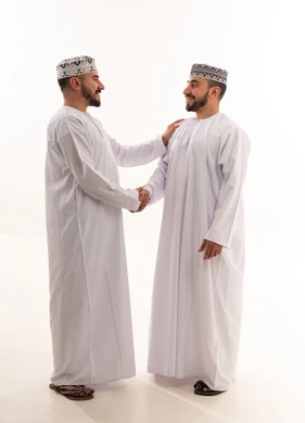 رجال عمانيون بالزي التقليدي يتبادلون المصافحة خلفية بيضاء