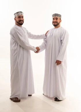 رجلان عمانيان يتصافحان بالزي التقليدي العماني في استوديو