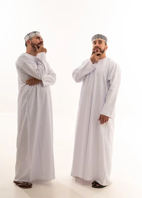 رجلان عمانيان بالزي التقليدي في وضعية تفكير