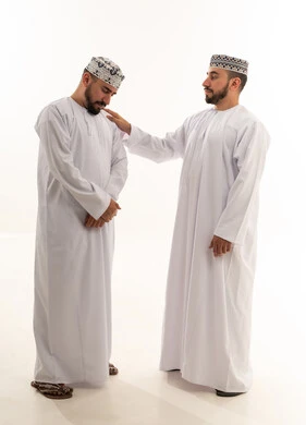 رجال عمانيون بالزي التقليدي في وضعية مواساة