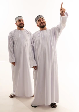 رجلان عمانيان بالزي التقليدي يشيران للأعلى