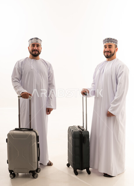 رجال عمانيون بالزي التقليدي مع حقائب سفر