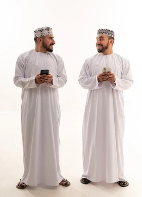 رجال عمانيون بالزي التقليدي مع هواتف ذكية