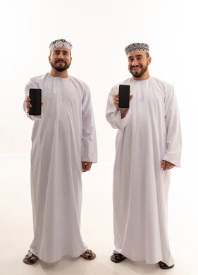 رجال عمانيون بالزي التقليدي يحملون هواتف ذكية حديثة