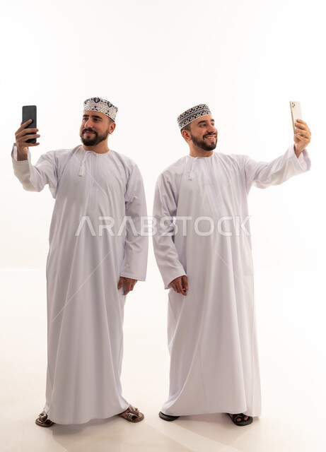 رجال عمانيون يلتقطون صور سيلفي بالهواتف الذكية