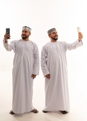 رجال عمانيون يلتقطون صور سيلفي بالهواتف الذكية