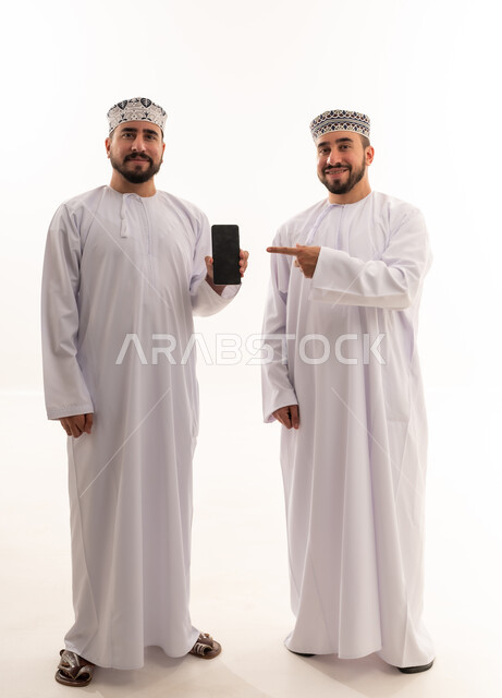 رجال عمانيون مع هاتف ذكي بخلفية بيضاء