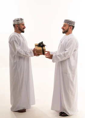 Omani Men Exchanging Gift Box in Traditional Dress