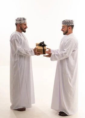 Omani Men Exchanging Gift in Traditional Attire