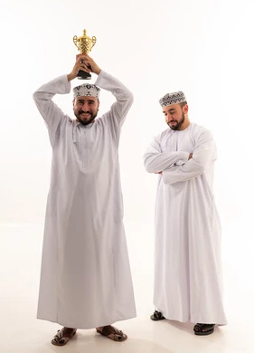 رجال عمانيون يحتفلون بالفوز مع كأس ذهبي