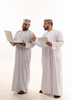 رجال أعمال عمانيون مع لابتوب وإيماءة نجاح