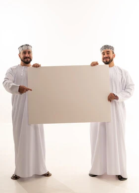 رجلان عمانيان يحملان لوحة بيضاء فارغة للإعلانات