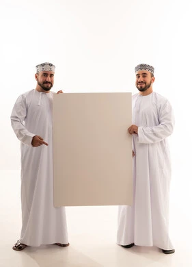 رجلان عمانيان يحملان لوحة إعلانية بيضاء فارغة