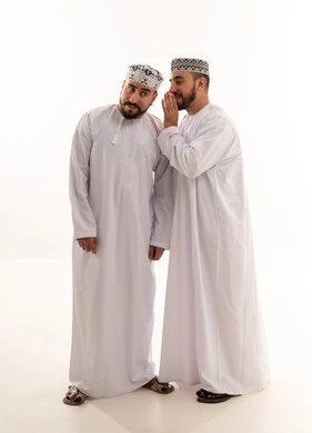 رجال عمانيون باللباس التقليدي يتهامسون بسر