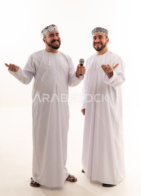 رجال عمانيون بالزي التقليدي يمسكون بميكروفون