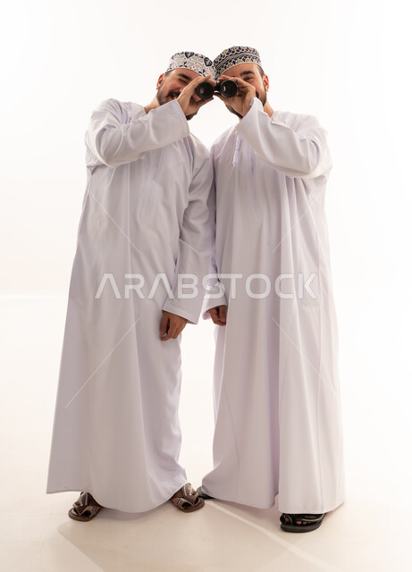Omani Men in Traditional Dress Using Binoculars