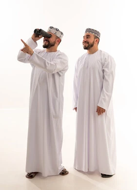 رجال عمانيون بالزي التقليدي يستخدمون المنظار