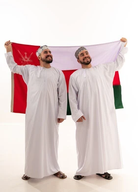 رجال عمانيون يحملون العلم العماني بالزي التقليدي