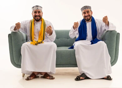 رجال عمانيون بالزي التقليدي يحتفلون على الأريكة