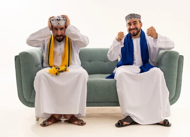رجال عمانيون بملابس تقليدية يتفاعلون مع مباراة