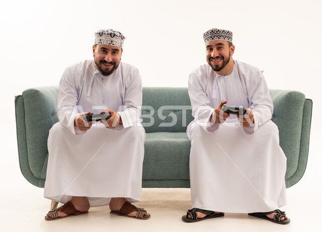 Omani Men Playing Video Games on Sofa Studio