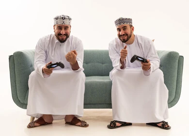 Omani Men Playing Video Games in Traditional Attire