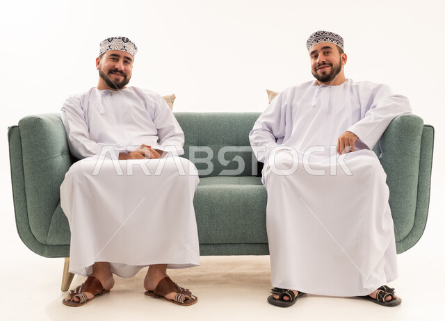 رجال عمانيون بالزي التقليدي يجلسون على أريكة