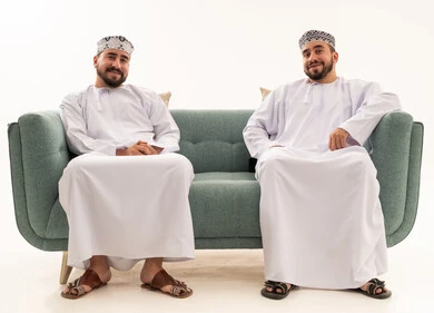 Omani Men in Traditional Dishdasha Sitting on Sofa