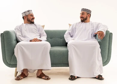 Omani Men in Traditional Dishdasha Sitting on Sofa