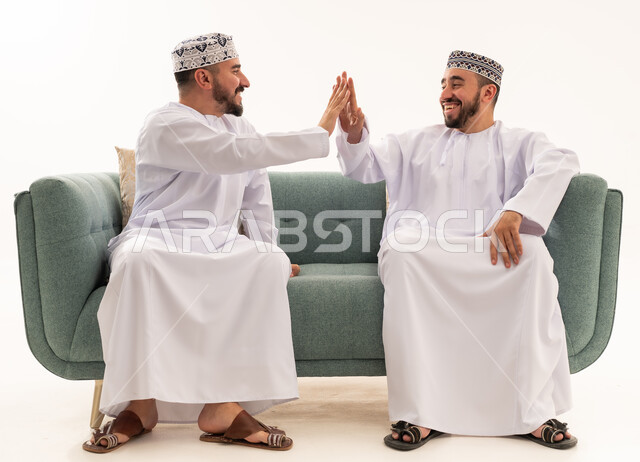 رجال عمانيون بالزي التقليدي يتبادلون التحية باليد