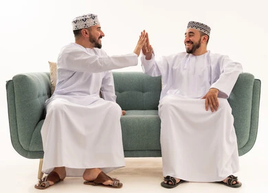 Omani Men in Traditional Dishdasha Giving High Five