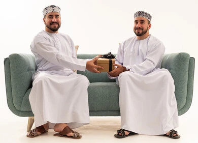 رجلان عمانيان يتبادلان الهدايا في استوديو خلفية بيضاء