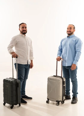 رجلان سعوديان مع حقائب سفر على خلفية بيضاء