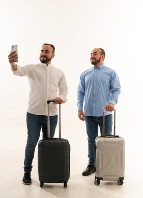 رجلان سعوديان مع حقائب سفر يلتقطان صورة سيلفي