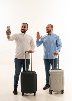رجال سعوديون مع حقائب سفر يلتقطون سيلفي بخلفية بيضاء
