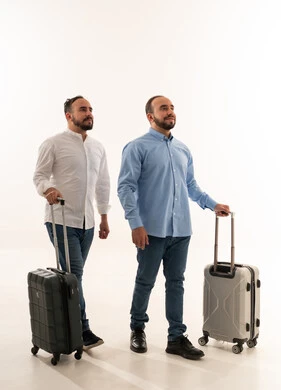 رجلان سعوديان مع حقائب سفر على خلفية بيضاء