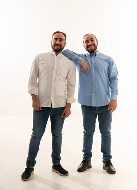 رجلان سعوديان بملابس كاجوال أمام خلفية بيضاء