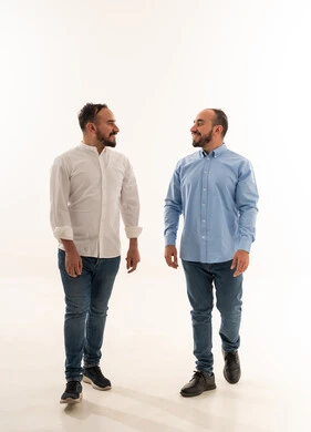 رجلان سعوديان يمشيان ويتحدثان بخلفية بيضاء