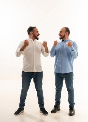 رجلان سعوديان يحتفلان بالنجاح على خلفية بيضاء