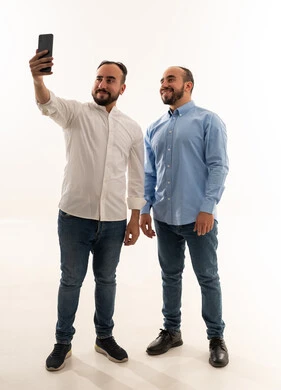 رجلان سعوديان يلتقطان سيلفي بالهاتف في الاستوديو