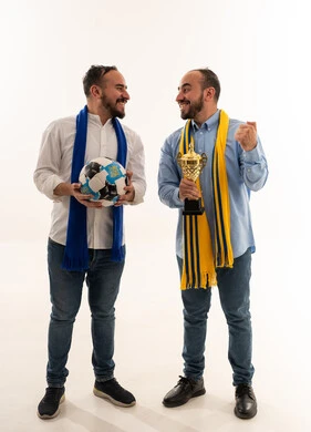 رجلان سعوديان يحتفلان بفوز كرة القدم مع الكأس