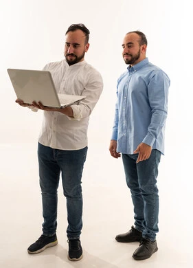 رجلان سعوديان يستخدمان لابتوب بخلفية بيضاء