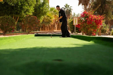 رجل سعودي يلعب الميني غولف في الهواء الطلق