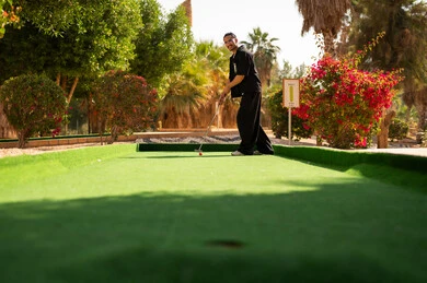 Saudi Man Playing Mini Golf at Outdoor Resort