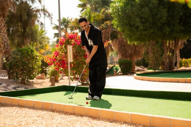 Saudi Man Playing Mini Golf at Outdoor Park