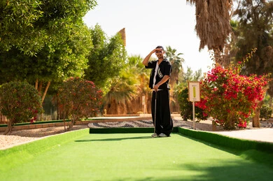 رجل عربي يلعب ميني غولف في الهواء الطلق