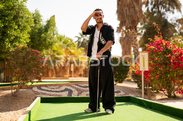 رجل سعودي يلعب الميني غولف في الخارج