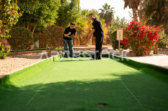 Arab Men Playing Mini Golf Outdoors in Daylight